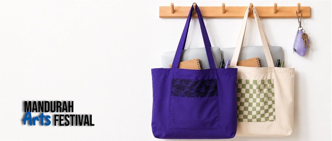 two handmade tote bags, one purple and one white with green checks, hang on wooden pegs on a wall